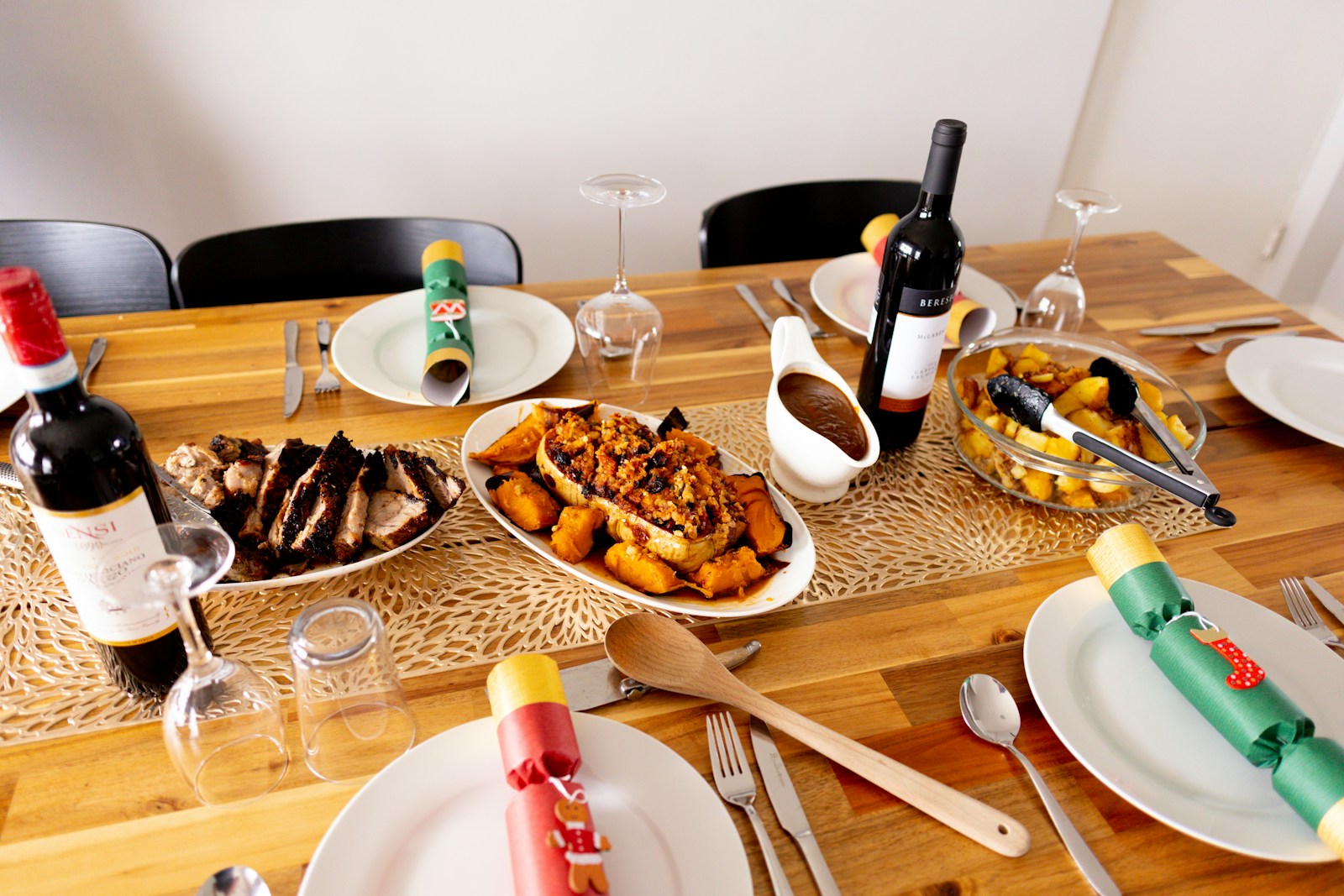 a wooden table topped with plates of food and wine